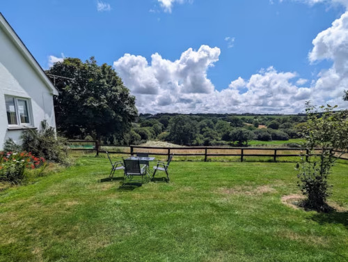 A view from the annex garden. Sunny, with clouds and trees in back ground.